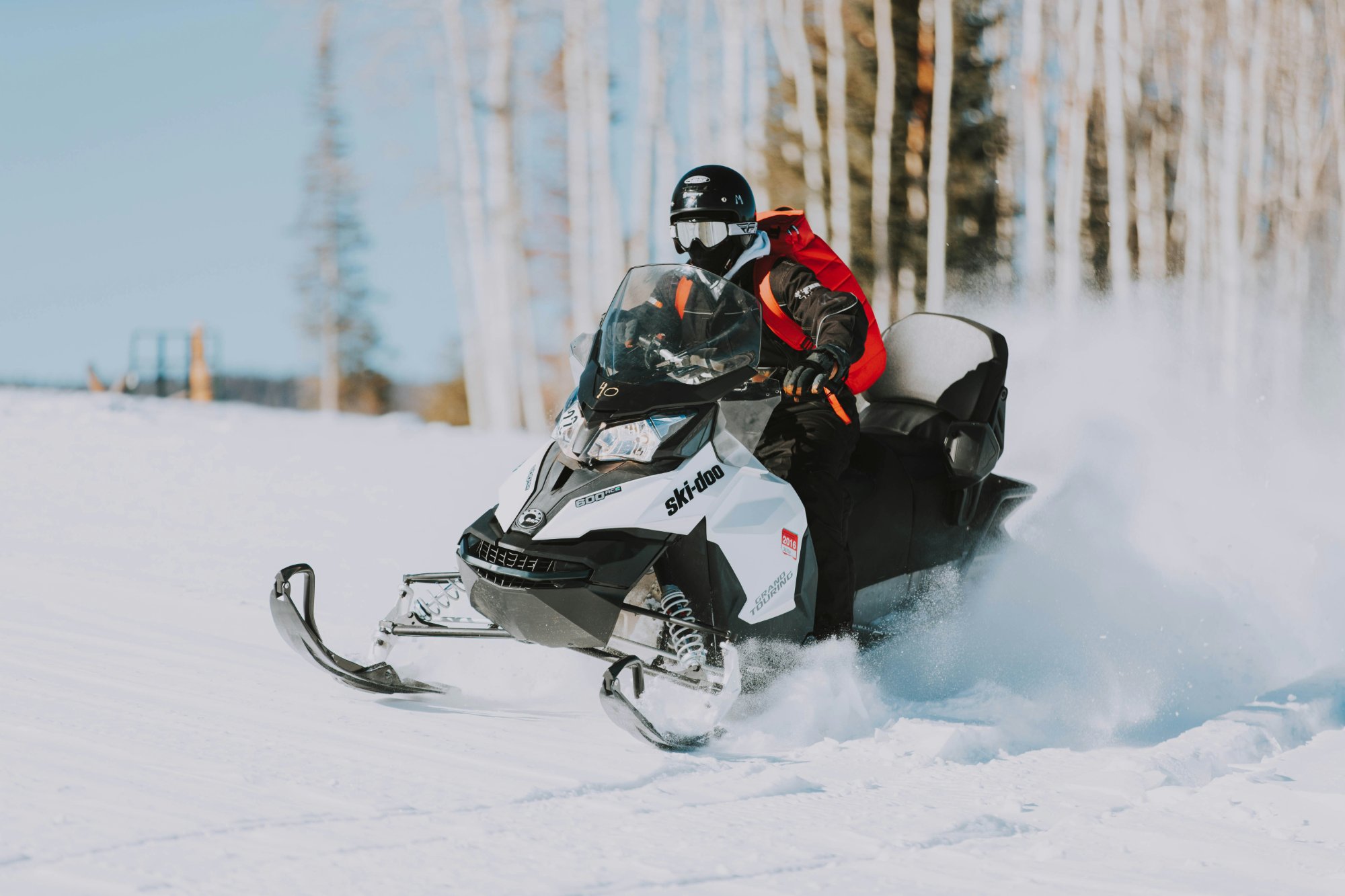 Snowmobiler riding through fresh powder snow